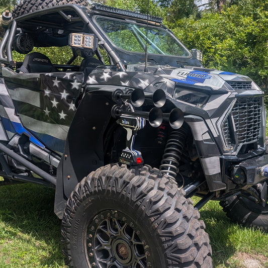 Thin BLUE Line TecHorns 4-Horn – handheld train horn with 20 V lithium battery, displayed on the front tire of a Thin BLUE Line wrapped UTV