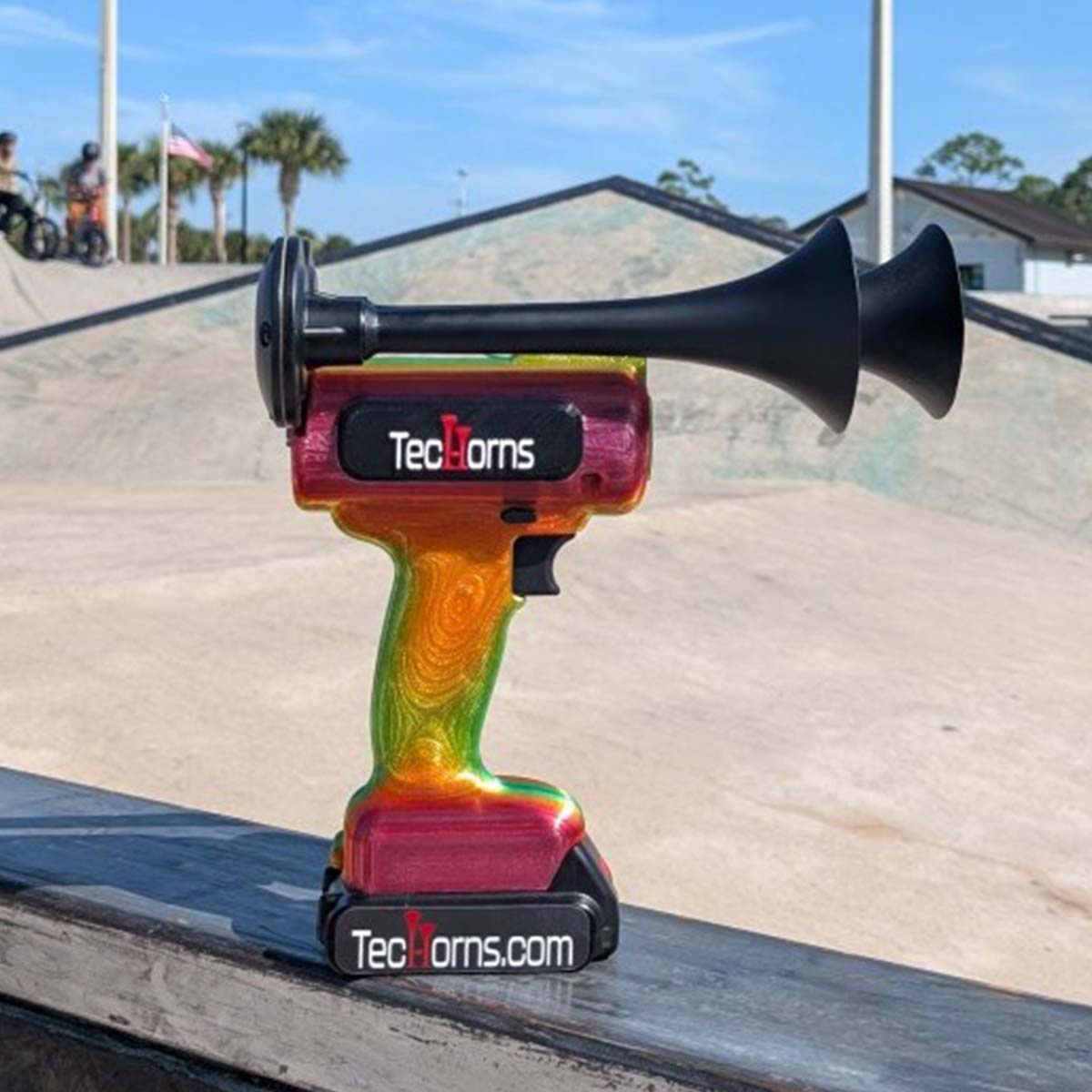 TecHorns Tropical Blaze Candy 2-Horn – 130 dB handheld train horn with 20 V lithium battery, shown at a skate park with its vivid candy fade colors capturing a bold, action-ready vibe