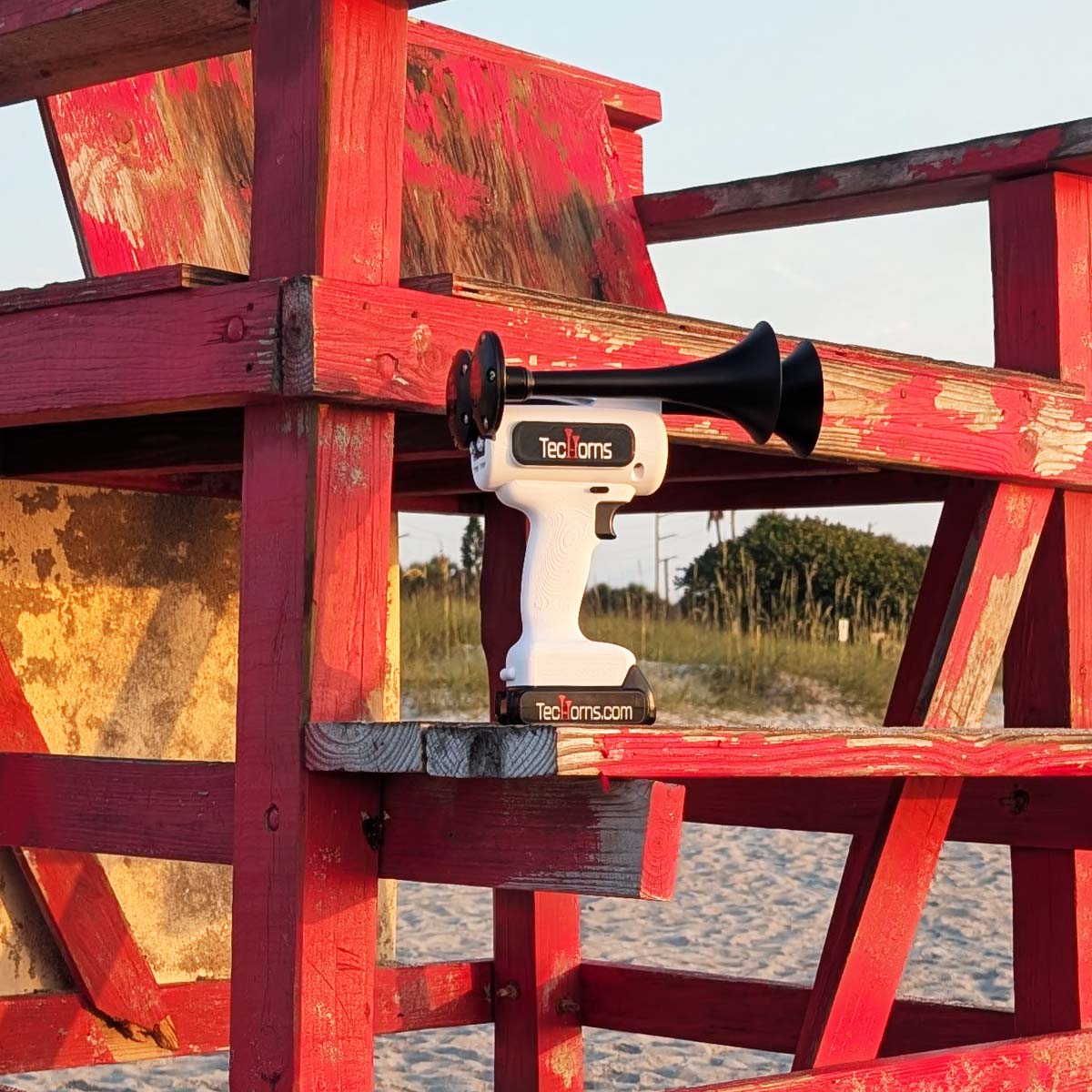 TecHorns White 2-Horn – single color handheld train horn with 20V lithium battery, photographed on a lifeguard stand by the beach