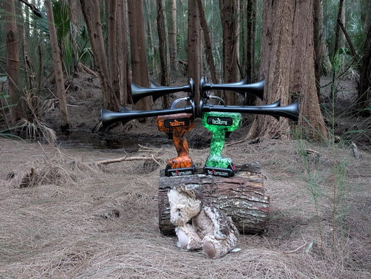 Abandoned teddy bear and twin TecHorns sit quietly on a log in the dark woods. It's a haunting Halloween setup that feels straight out of a horror movie.
