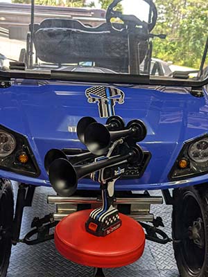 Thin BLUE Line TecHorn 4-Horn – handheld train horn with 20 V lithium battery, displayed in front of a custom blue golf cart with a Thin BLUE Line Punisher decal honoring law enforcement pride and unity