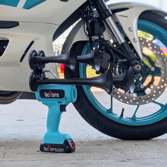 TecHorns Baby Blue 4-Horn – single color handheld train horn, 130 dB loud with 20V lithium battery, photographed with white and teal street bike in the background
