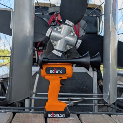 TecHorns Orange 2-Horn – single color handheld train horn with 20V lithium battery, photographed in front of an airboat’s propeller