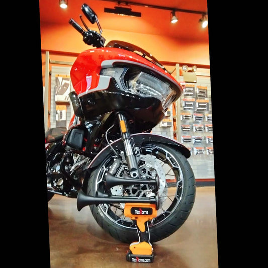 TecHorns Orange, White, and Black 4-Horn – triple color handheld train horn, 130 dB with 20 V lithium battery, photographed in front of orange and black Harley Davidson SVO motorcycle