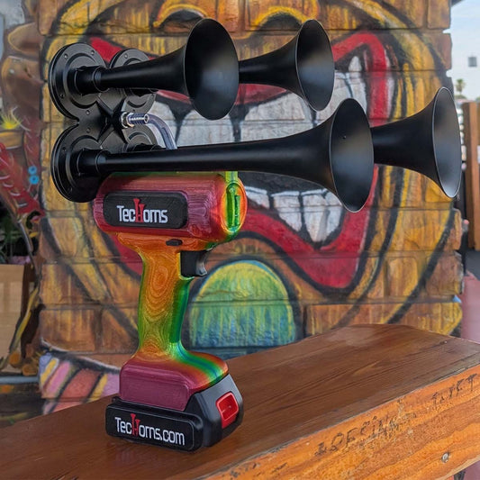 TecHorns Tropical Blaze Candy 4-Horn – handheld train horn with 20 V lithium battery, shown in front of a colorful tiki mural that complements the red-to-orange-to-green candy fade finish